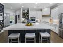 Modern kitchen with a large island, white cabinetry, stainless steel appliances, and stylish bar stools at 570 Society St, Alpharetta, GA 30022