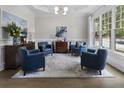 Bright living room with hardwood floors, stylish blue chairs, and a large window at 570 Society St, Alpharetta, GA 30022