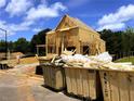 Two-story home during construction, with dumpsters and wood piles in foreground at 675 Crest Line Trl, Powder Springs, GA 30127