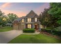 Charming two-story home boasts a manicured lawn, brick accents, and inviting front porch at 6597 River Island Drive Dr, Buford, GA 30518