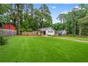Beautiful home exterior featuring a lush green lawn and mature trees in a serene, fenced in backyard setting at 1564 Belva Ave, Decatur, GA 30032