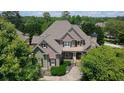 Aerial view of a brick home surrounded by lush trees and landscaped yard at 3451 Falls Branch Ct, Buford, GA 30519