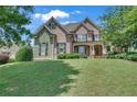 Attractive brick home featuring shuttered windows and a well-manicured lawn at 3451 Falls Branch Ct, Buford, GA 30519