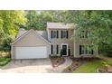 Traditional two-story home with a two-car garage, manicured lawn, and mature trees at 5679 Bay Harbor Nw Trl, Acworth, GA 30101