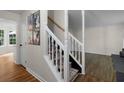 Bright foyer features hardwood floors, white staircase, and modern decor at 5679 Bay Harbor Nw Trl, Acworth, GA 30101