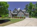 Beautiful two-story home with a well-manicured lawn, attached garage, and long driveway at 1231 Fawndale Nw Dr, Kennesaw, GA 30152