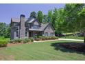 Inviting brick home with a manicured lawn and mature trees, creating a serene curb appeal at 1231 Fawndale Nw Dr, Kennesaw, GA 30152