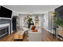 Bright living room features a fireplace, hardwood floors, lots of plants, and large windows for plenty of light at 303 Gettysburg Pl, Atlanta, GA 30350