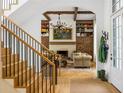 Inviting living room with hardwood floors, a fireplace flanked by built-in bookshelves, and elegant staircase at 11277 Serenbe Ln, Chattahoochee Hills, GA 30268