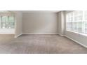Spacious living room with neutral-toned carpet, large windows, and natural light, creating a welcoming atmosphere at 3732 Landgraf Cv, Decatur, GA 30034