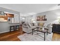 Bright living room with hardwood floors, a comfortable couch, and a view into the dining area at 3408 Lake Pointe Cir, Roswell, GA 30075