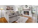 Cozy living room with a fireplace, hardwood floors, and a neutral color palette at 3408 Lake Pointe Cir, Roswell, GA 30075