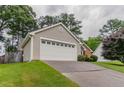 Attached garage with a long driveway and well-manicured lawn at 1115 Hunters Creek Ct, Lawrenceville, GA 30043