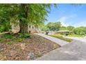 A lush tree shades this house, with its brick exterior, a wide concrete driveway, and easy street access at 1381 Benteen Way Southeast, Atlanta, GA 30315