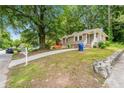Exterior view of a charming house with a brick facade, concrete driveway, and a lush lawn at 1381 Benteen Way Southeast, Atlanta, GA 30315