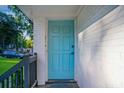 Close up of the light blue, paneled front door with a black handle and sidelight at 1398 Woodland Ave, Atlanta, GA 30316