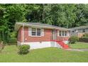Cozy red brick home with well maintained lawn and red stairs surrounded by green trees at 2329 Polar Rock Sw Ave, Atlanta, GA 30315