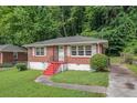 Well-kept red brick home featuring a green lawn and a vibrant red staircase leading to the front door at 2329 Polar Rock Sw Ave, Atlanta, GA 30315