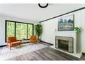 Inviting living room with hardwood floors, fireplace, and a large window with views of a lush green yard at 2343 Dawn Dr, Decatur, GA 30032
