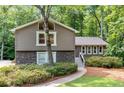 Charming home featuring stone accents and gray trim, surrounded by lush landscaping and mature trees at 2717 Hearthstone Cir, Marietta, GA 30062