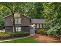 Charming home featuring stone accents and gray trim, surrounded by lush landscaping and mature trees at 2717 Hearthstone Cir, Marietta, GA 30062