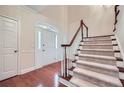 Bright foyer featuring hardwood floors, a staircase, and a front door with decorative glass at 7155 Roswell Rd # 58, Atlanta, GA 30328