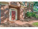 Close up of brick home showcasing an arched portico and inviting red front door at 7155 Roswell Rd # 58, Atlanta, GA 30328