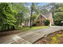 Spacious brick home on a sprawling lot with a long driveway and mature trees providing ample shade at 1595 Bakers Glen Dr, Atlanta, GA 30350