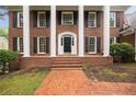 Close-up of the stately brick home featuring white columns, a black front door, and brick stairs at 1595 Bakers Glen Dr, Atlanta, GA 30350
