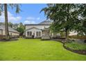 Spacious backyard with a well-maintained lawn, mature trees, and a large deck, perfect for entertaining at 525 Arbor Creek Ct, Roswell, GA 30076
