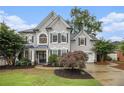 Charming gray two-story home with manicured lawn and beautiful landscaping at 525 Arbor Creek Ct, Roswell, GA 30076