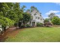 Charming two-story home with beautiful landscaping, manicured lawn and classic architectural details at 525 Arbor Creek Ct, Roswell, GA 30076