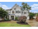 Charming two-story home with beautiful landscaping, manicured lawn and classic architectural details at 525 Arbor Creek Ct, Roswell, GA 30076