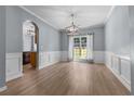 Elegant dining room with hardwood floors, modern lighting, and wainscoting, perfect for Gathering gatherings at 211 Augusta Woods Dr, Villa Rica, GA 30180