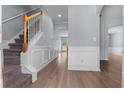 Inviting entryway with wood floors, staircase, and decorative wainscoting for an elegant touch at 211 Augusta Woods Dr, Villa Rica, GA 30180