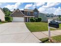 Charming two-story home with brick accents, a well-manicured lawn, and a spacious driveway at 211 Augusta Woods Dr, Villa Rica, GA 30180