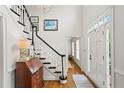 Bright foyer with a staircase featuring elegant black and white trim, hardwood floors, and an antique desk at 4792 Fairville Ct, Marietta, GA 30062