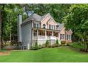 Beautiful two-story home with a brick and siding exterior, covered porch, and landscaped front yard at 5301 Regency Lake Ct, Sugar Hill, GA 30518