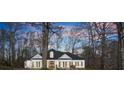 A well-kept single-Gathering home with a dark roof stands out in the sunset, framed by bare winter trees at 6170 Wellington Ct, Cumming, GA 30040