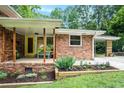 Inviting front porch with yellow door, wooden columns, and landscaped garden beds at 1706 Remington Rd, Atlanta, GA 30341