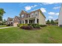 Beautiful home with a lush green lawn, colorful landscaping, and a welcoming front porch at 7190 Tributary Ct, Cumming, GA 30040