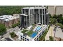 Aerial view of a modern building featuring a pool, tennis court, and green space at 2425 Peachtree Ne Rd # 902, Atlanta, GA 30305
