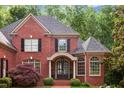 Stately brick home showcases a welcoming entrance with detailed windows and manicured bushes, enhancing its elegant facade at 63 Lewellen Dr, Marietta, GA 30064