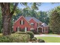 Stunning brick home with mature landscaping, black shutters, and a welcoming front entrance at 63 Lewellen Dr, Marietta, GA 30064