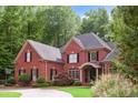 Well-maintained brick home with black shutters and verdant landscaping, complete with a basketball hoop, providing great outdoor appeal at 63 Lewellen Dr, Marietta, GA 30064