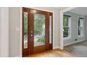 Elegant foyer featuring hardwood floors, a decorative front door, and neutral wall paint at 9800 Woodfall Dr, Roswell, GA 30076