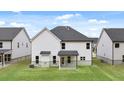 A rear view showing the ample backyard and a covered porch of a two story residence at 13567 Whitman Lane, Covington, GA 30014