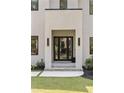 Elegant modern home entrance with double doors, decorative lighting, and lush landscaping at 3293 Lenox Ne Pl, Atlanta, GA 30324