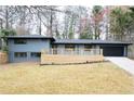 Contemporary home featuring a painted brick exterior, large front porch, and a black garage door at 1120 Taliwa Ne Trl, Marietta, GA 30068