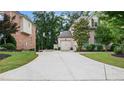 Spacious driveway leading to an attached garage with mature trees surrounding the home at 1980 Marcia Overlook Dr, Cumming, GA 30041